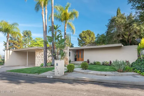 a front view of a house with a yard and a garage