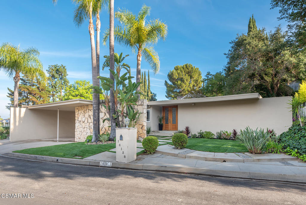 16138 Meadowcrest Road Sherman Oaks, CA 91403 - Photo 1 of 36 a front view of a house with a yard and a garage
