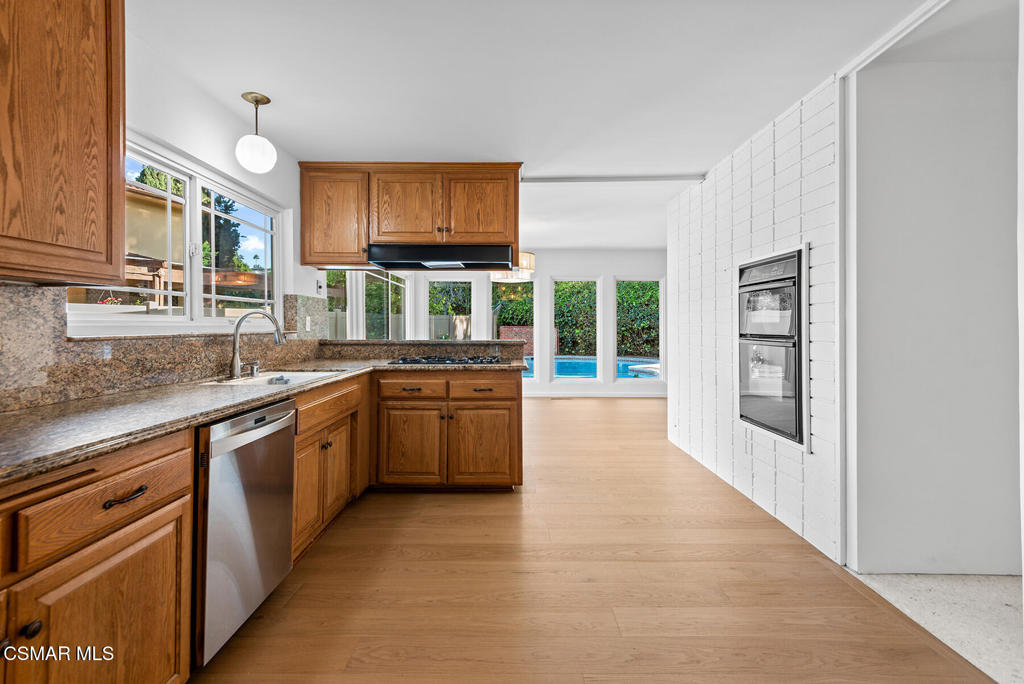 16138 Meadowcrest Road Sherman Oaks, CA 91403 - Photo 16 of 36 a large kitchen with stainless steel appliances granite countertop a stove and a sink