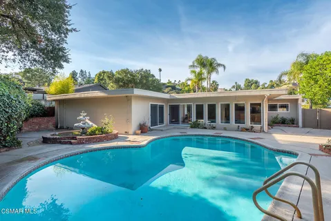 a view of a house with swimming pool and sitting area