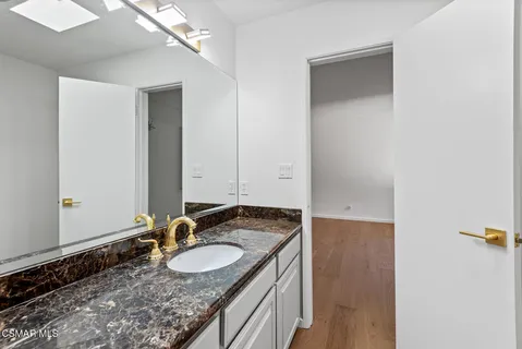 a bathroom with a granite countertop sink and a mirror