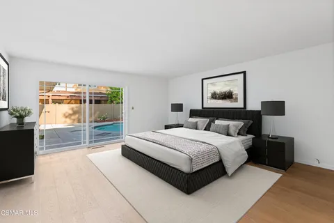 a spacious bedroom with a bed and glass door