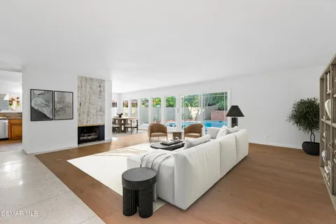 a living room with furniture a large window and a fireplace