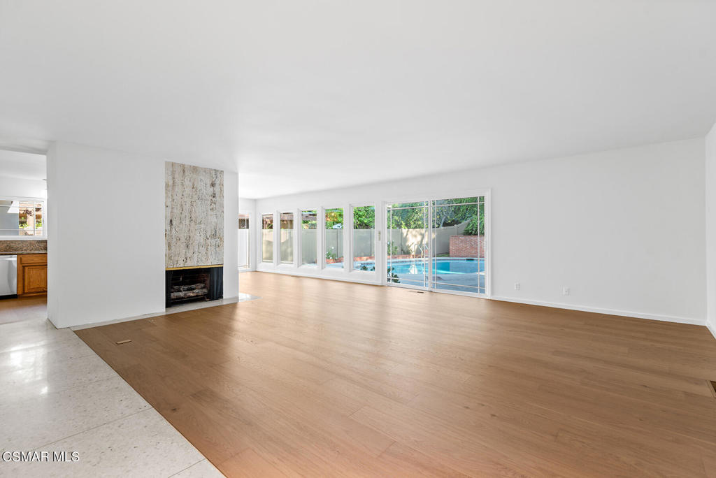 16138 Meadowcrest Road Sherman Oaks, CA 91403 - Photo 7 of 36 a view of an empty room with wooden floor and fireplace