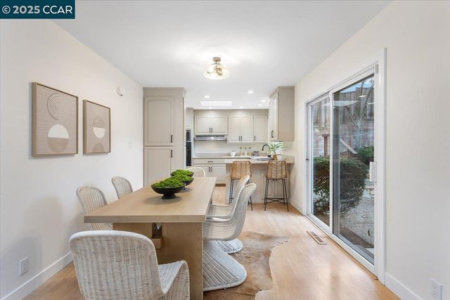 a view of a dining room with furniture a chandelier and wooden floor
