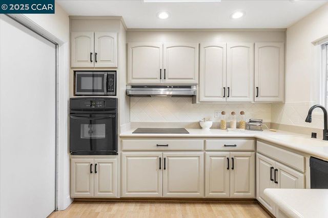 a kitchen with stainless steel appliances granite countertop a refrigerator and cabinets