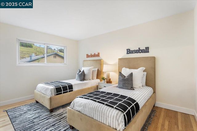 a bedroom with two beds and wooden floor