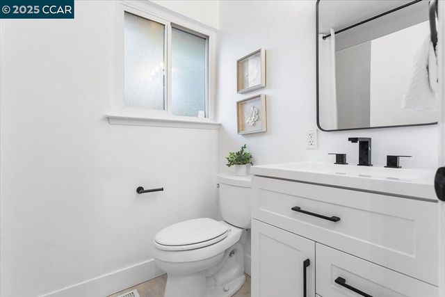 a bathroom with a sink vanity mirror and toilet