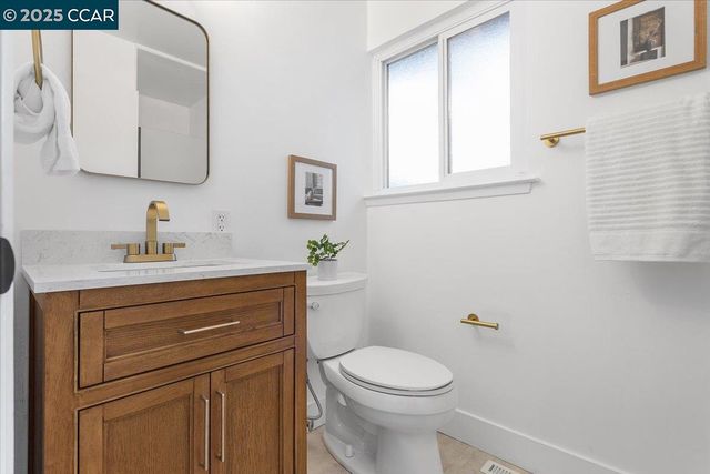 a bathroom with a toilet a sink a vanity and mirror