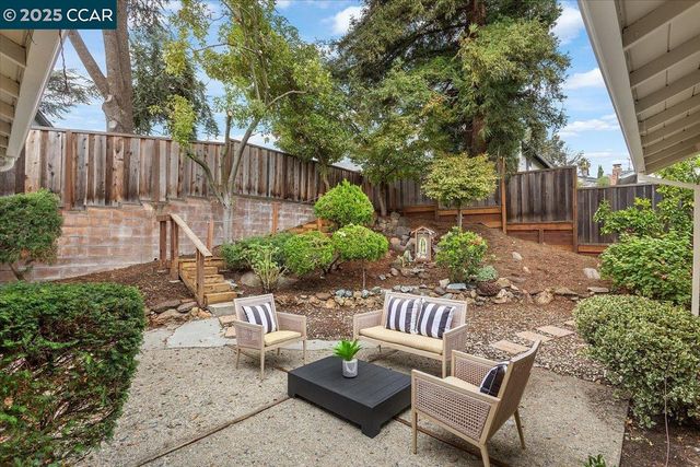 a view of a chairs and table in the backyard