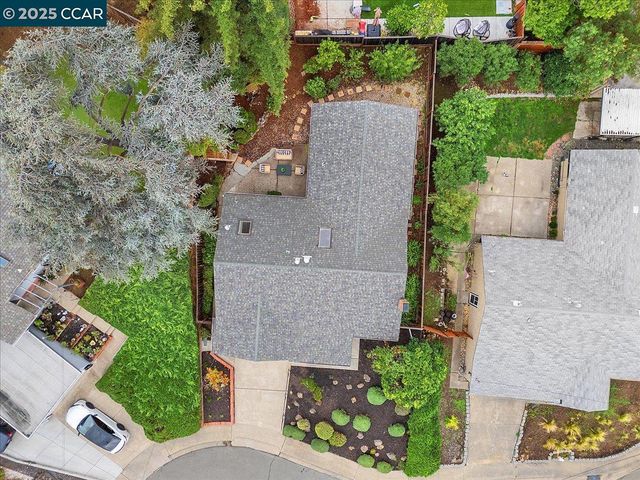 an aerial view of a house with a garden and trees