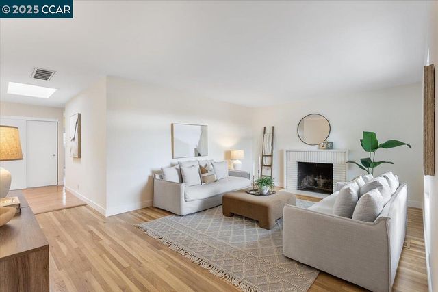 a living room with furniture a fireplace and a potted plant