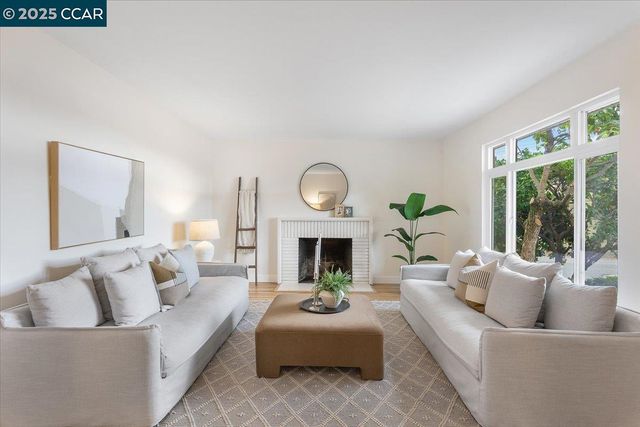a living room with furniture a fireplace and a large window