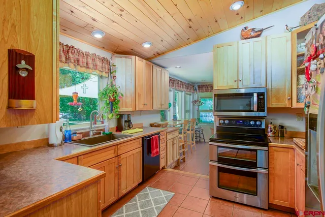 a kitchen with stainless steel appliances a stove sink and microwave