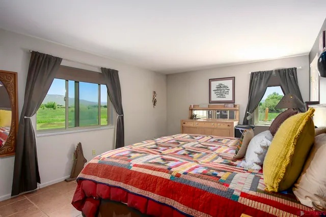 a bedroom with a bed and a large window