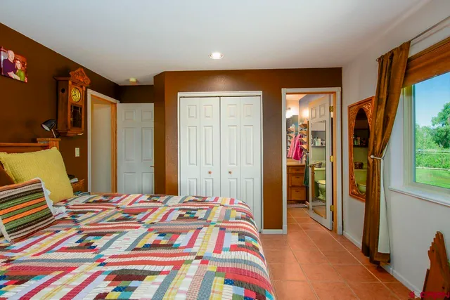 a bedroom with a bed and a large mirror in front of it