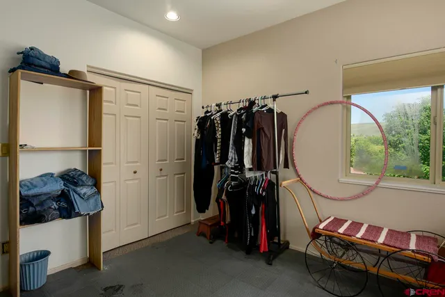 a view of walk in closet with clothes and shoes