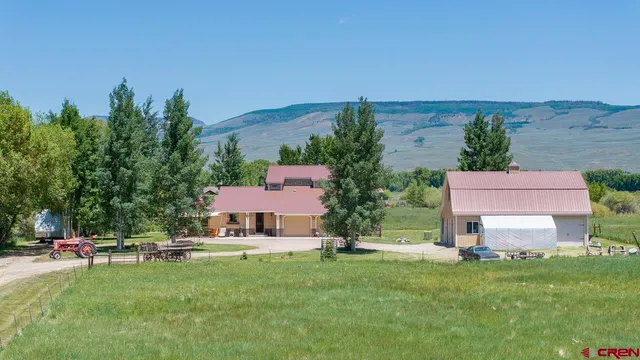 an aerial view of a house with swimming pool and yard