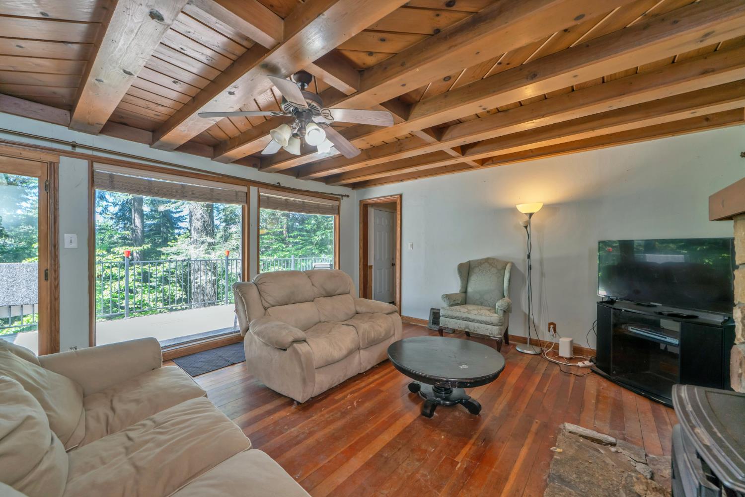 6929 Split Bend Road Pollock Pines, CA 95726 - Photo 23 of 38 a living room with furniture a flat screen tv and a large window