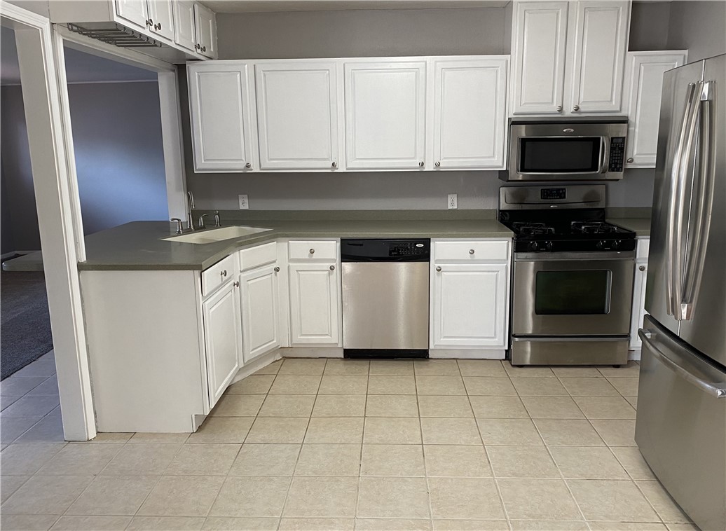 1010 Deforrest Street Corpus Christi, TX 78404 - Photo 4 of 22 a kitchen with granite countertop a stove a microwave and a refrigerator