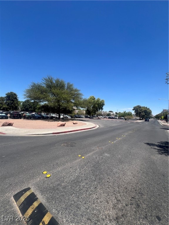 797 East Harmon Avenue, Unit 7 Las Vegas, NV 89119 - Photo 2 of 12 View of asphalt road featuring curbs, sidewalks, and street lights