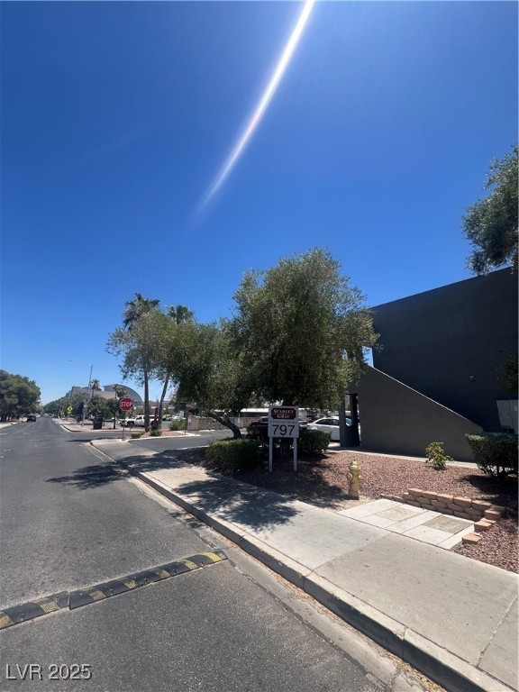 797 East Harmon Avenue, Unit 7 Las Vegas, NV 89119 - Photo 3 of 12 View of asphalt street with curbs, sidewalks, street lighting, and traffic signs
