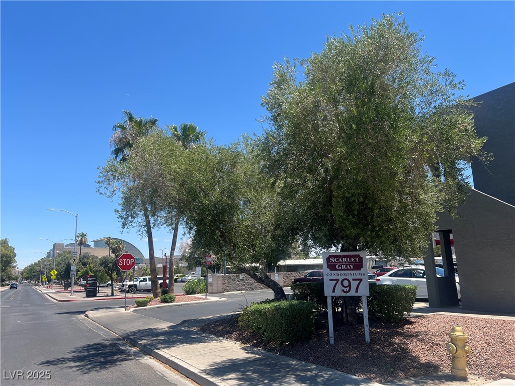 797 East Harmon Avenue, Unit 7 Las Vegas, NV 89119 - Photo 4 of 12 View of asphalt road featuring traffic signs, sidewalks, curbs, and street lights