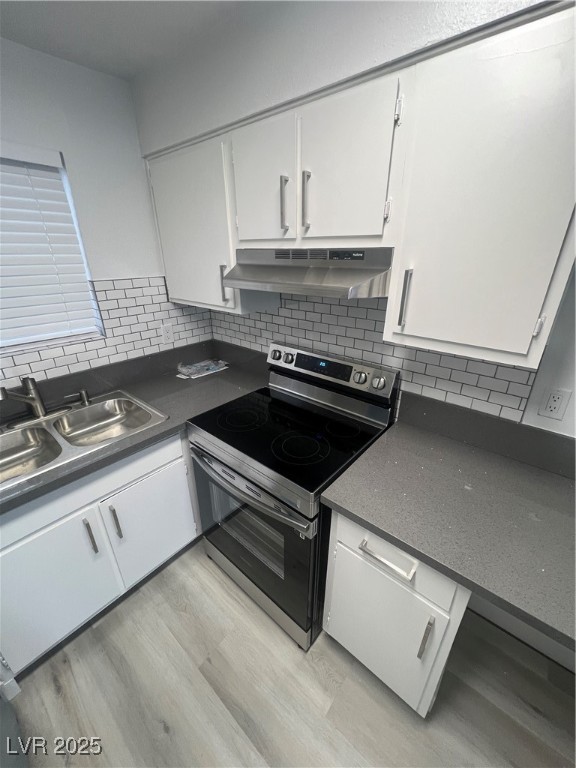797 East Harmon Avenue, Unit 7 Las Vegas, NV 89119 - Photo 7 of 12 Kitchen with electric stove, white cabinets, light wood finished floors, dark countertops, and ventilation hood