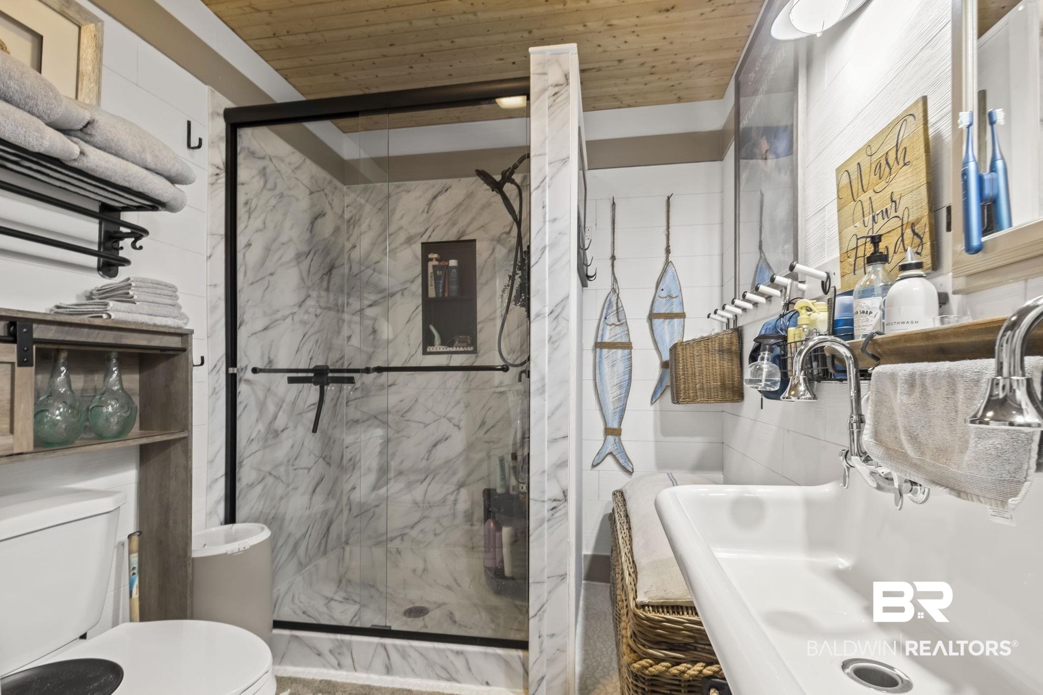 2514 Muscogee Road Gulf Shores, AL 36542 - Photo 25 of 60 Bathroom featuring an enclosed shower, sink, tile walls, wooden ceiling, and toilet