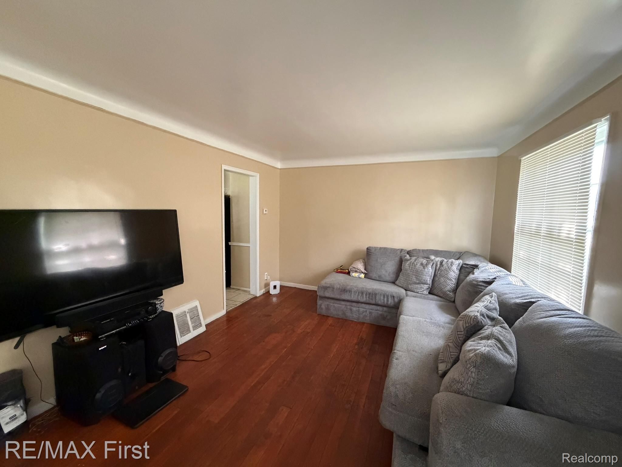18603 Moross Road Detroit, MI 48224 - Photo 2 of 16 Living area featuring wood-finish flooring, neutral wall tones, and crown molding