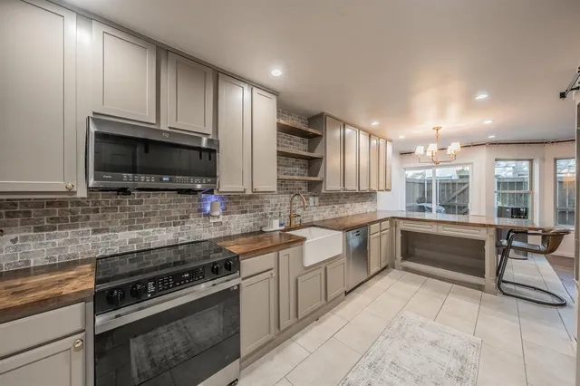 a kitchen with stainless steel appliances granite countertop a refrigerator and a sink