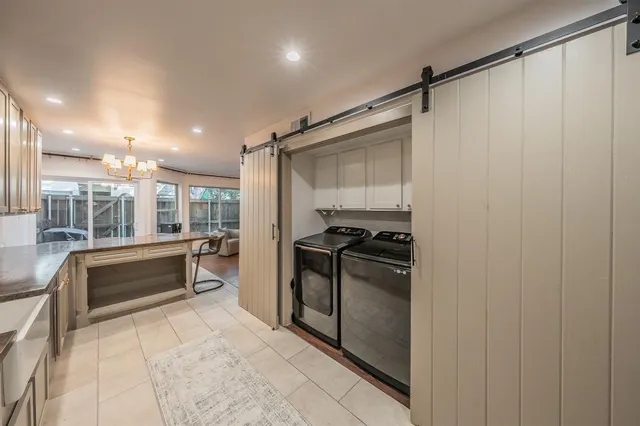 a view of a dining room with furniture large windows and a chandelier