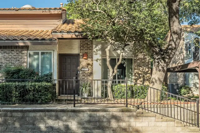 a view of a brick house with large windows