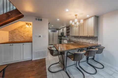 a view of a kitchen with kitchen island granite countertop wooden floors and a view of living room