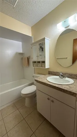 a bathroom with a granite countertop toilet a sink and a mirror