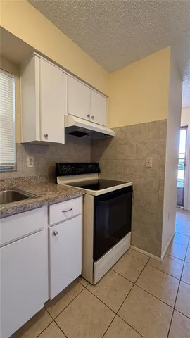 a kitchen with granite countertop white cabinets stainless steel appliances and a sink