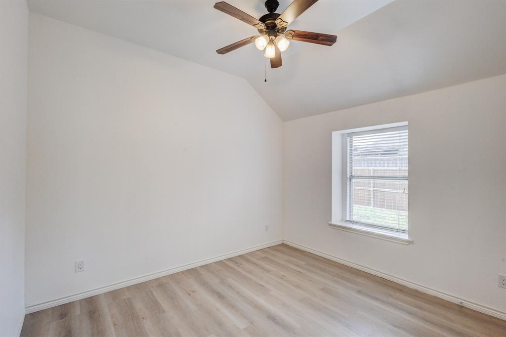 12405 Ark Road Frisco, TX 75035 - Photo 11 of 34 Unfurnished room with light wood-style floors, lofted ceiling, and a ceiling fan