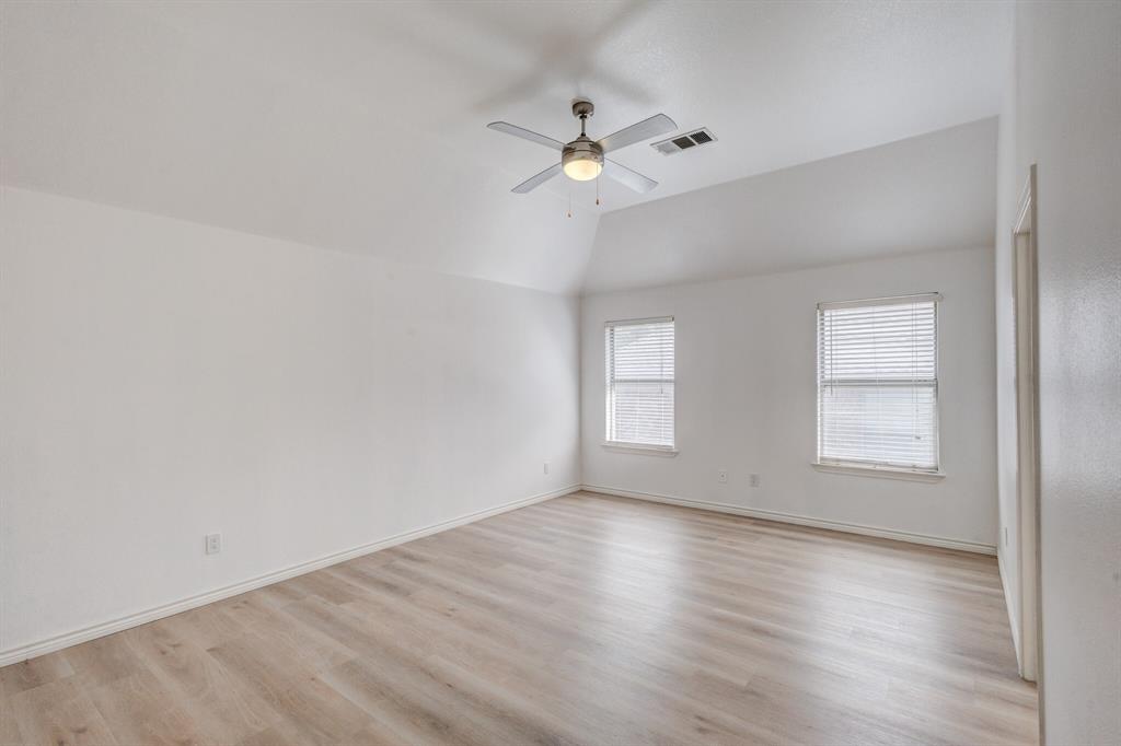 12405 Ark Road Frisco, TX 75035 - Photo 12 of 34 Unfurnished room with a ceiling fan, light wood-type flooring, and vaulted ceiling