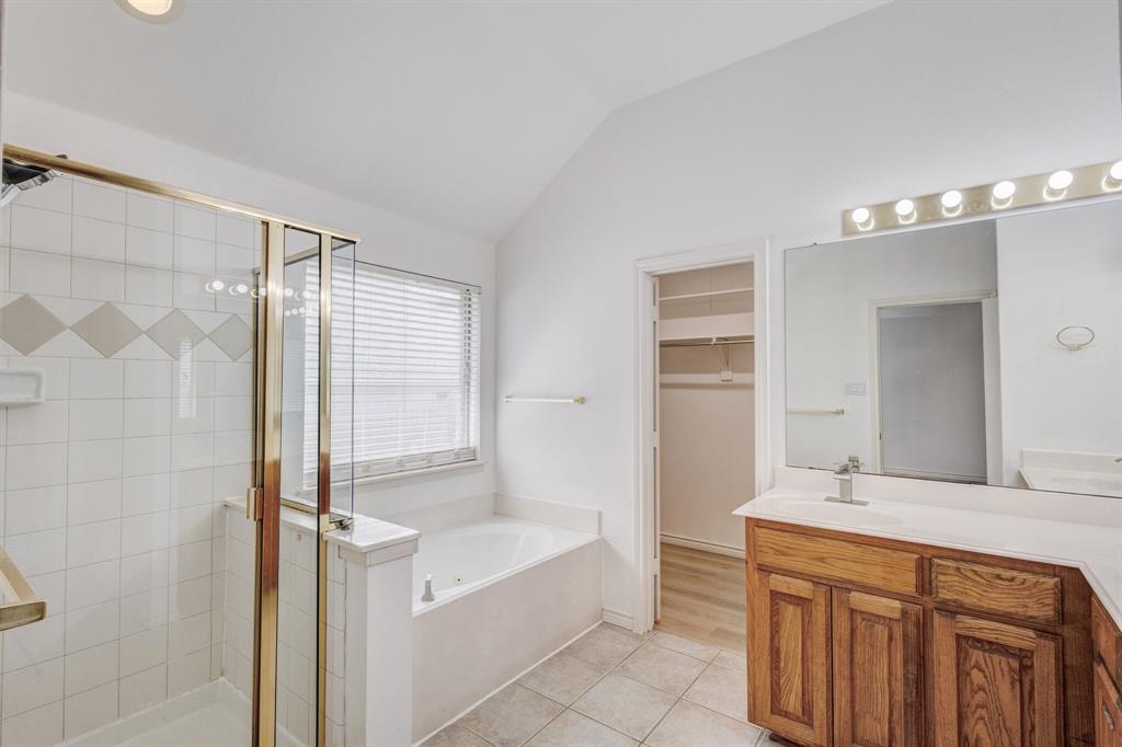 12405 Ark Road Frisco, TX 75035 - Photo 13 of 34 Bathroom with vanity, a stall shower, a spacious closet, a garden tub, and light tile patterned floors