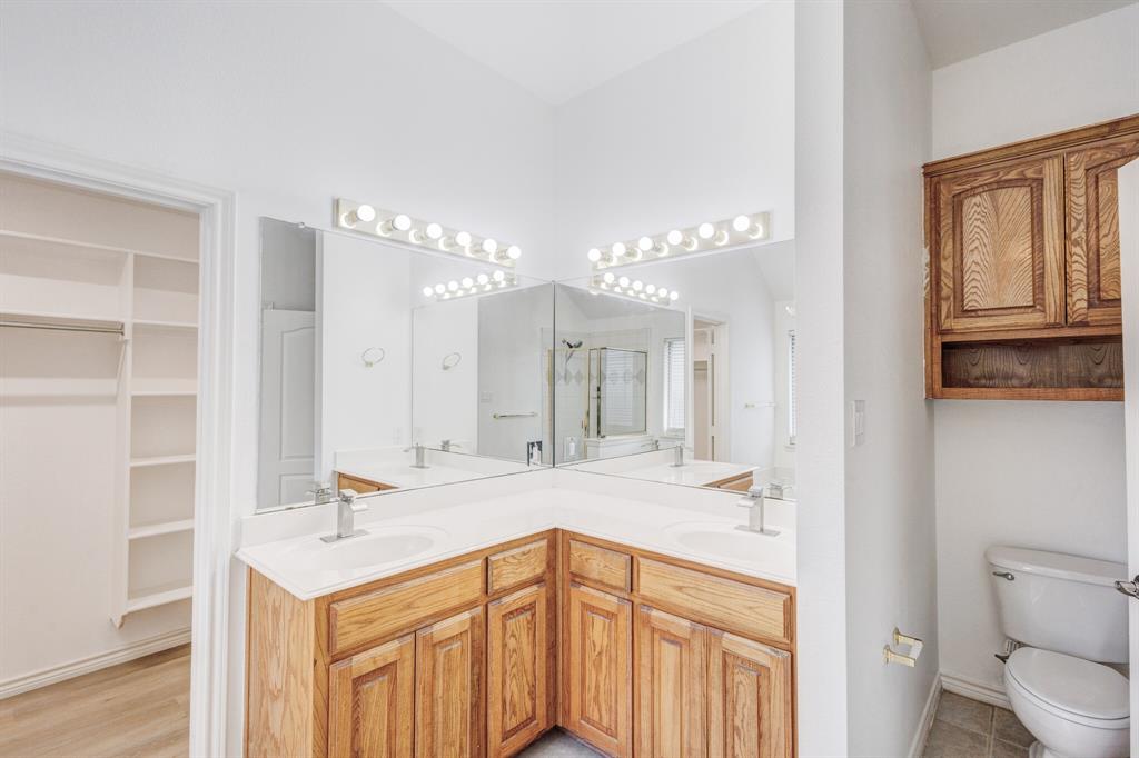 12405 Ark Road Frisco, TX 75035 - Photo 14 of 34 Full bathroom with double vanity, a walk in closet, and a shower stall