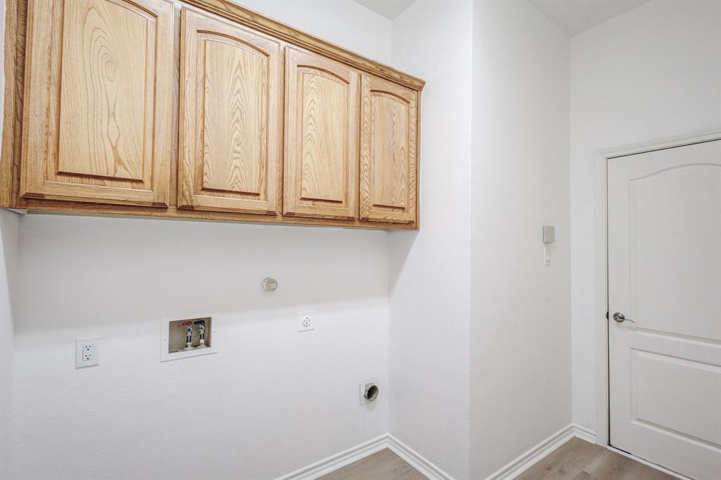 12405 Ark Road Frisco, TX 75035 - Photo 16 of 34 Laundry room featuring washer hookup, gas dryer hookup, cabinet space, light wood finished floors, and hookup for an electric dryer