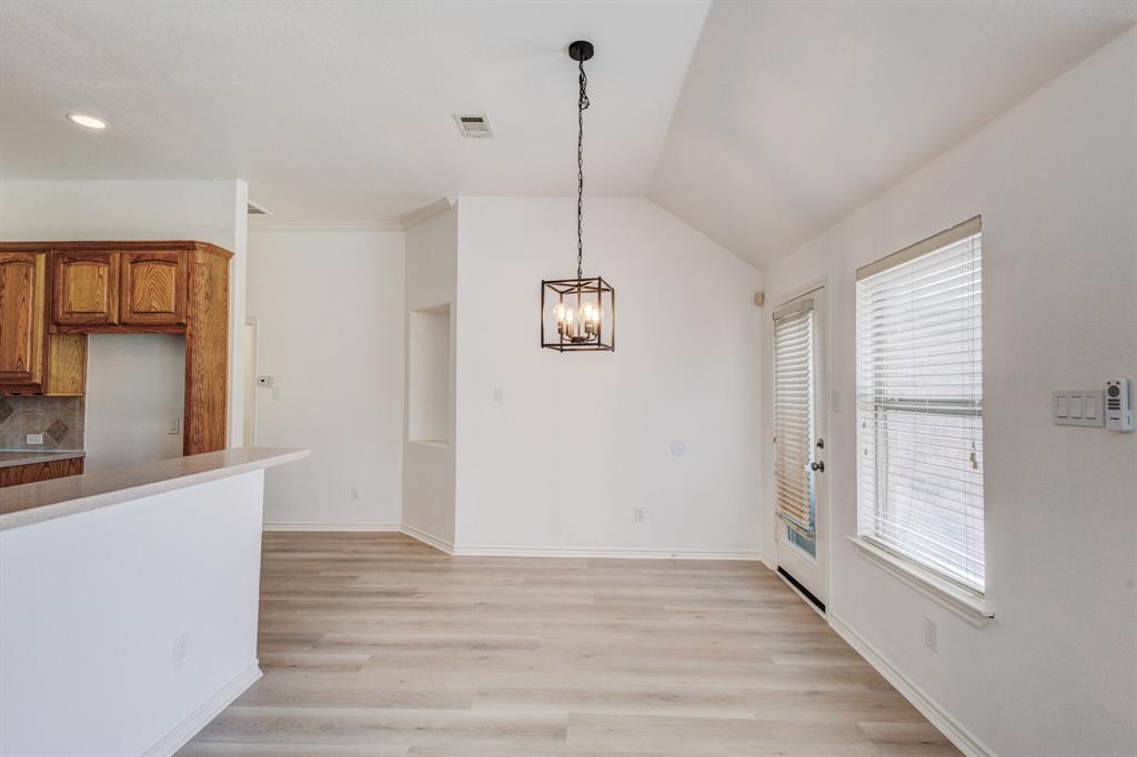 12405 Ark Road Frisco, TX 75035 - Photo 22 of 34 Unfurnished dining area with light wood-style floors, suspended lighting, and lofted ceiling