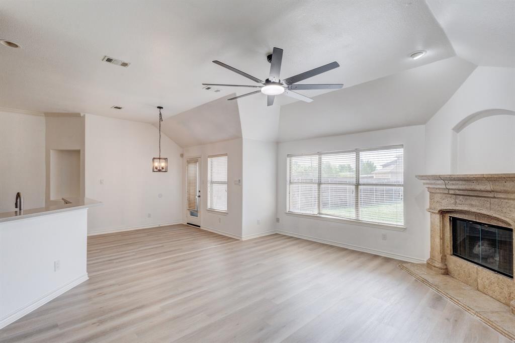 12405 Ark Road Frisco, TX 75035 - Photo 25 of 34 Unfurnished living room with a high end fireplace, lofted ceiling, light wood-style floors, and ceiling fan