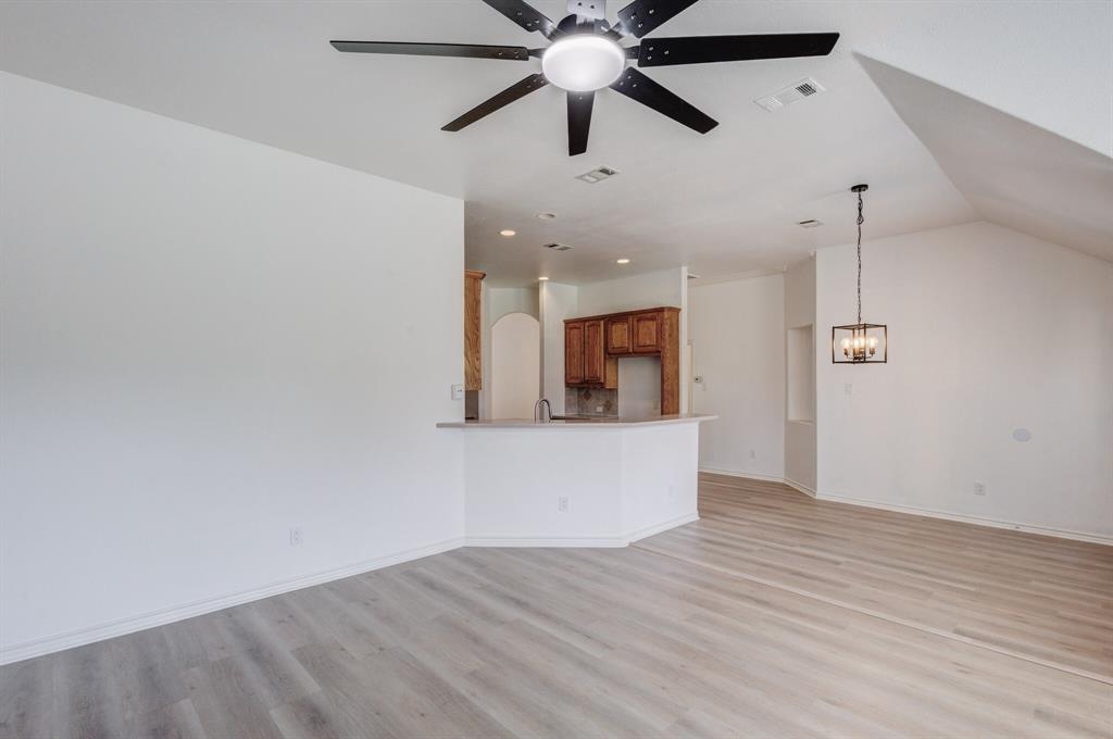 12405 Ark Road Frisco, TX 75035 - Photo 26 of 34 Unfurnished living room with light wood finished floors, ceiling fan, and vaulted ceiling