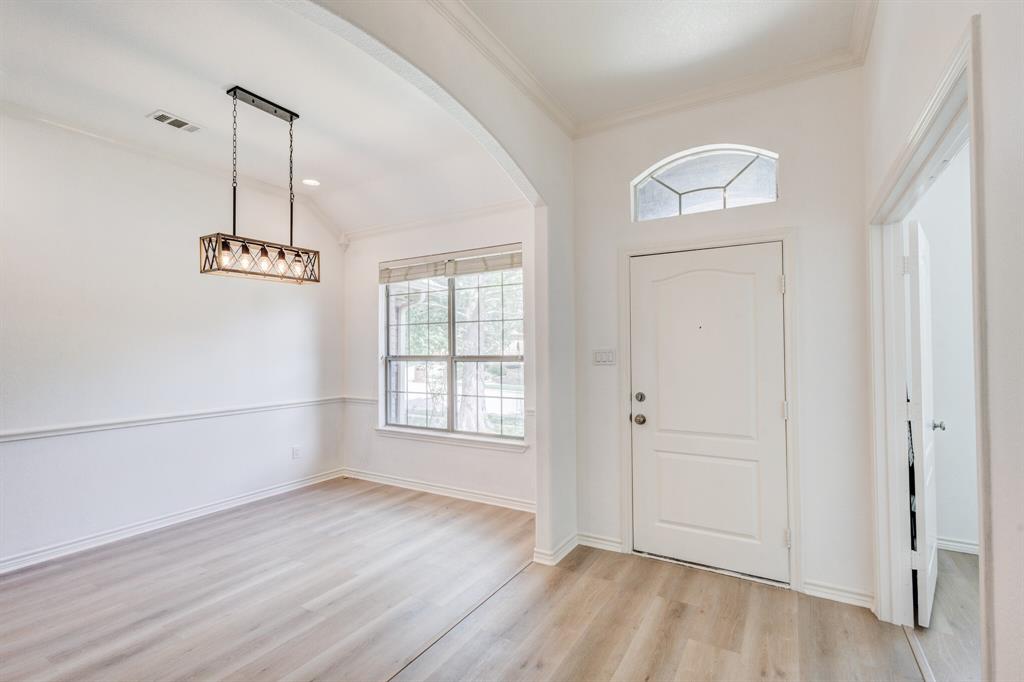 12405 Ark Road Frisco, TX 75035 - Photo 3 of 34 Entryway featuring light wood-style floors, vaulted ceiling, arched walkways, and ornamental molding