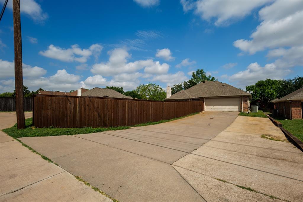 12405 Ark Road Frisco, TX 75035 - Photo 31 of 34 View of side of home featuring brick siding, a garage, and driveway