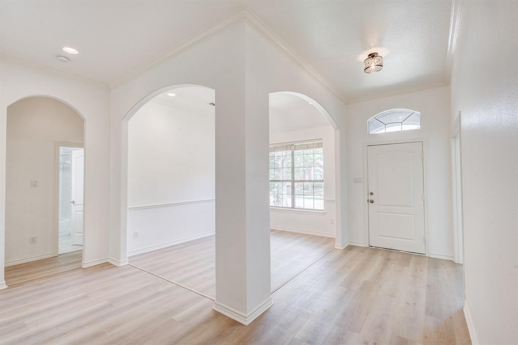 12405 Ark Road Frisco, TX 75035 - Photo 4 of 34 Entryway featuring arched walkways, ornamental molding, and light wood finished floors