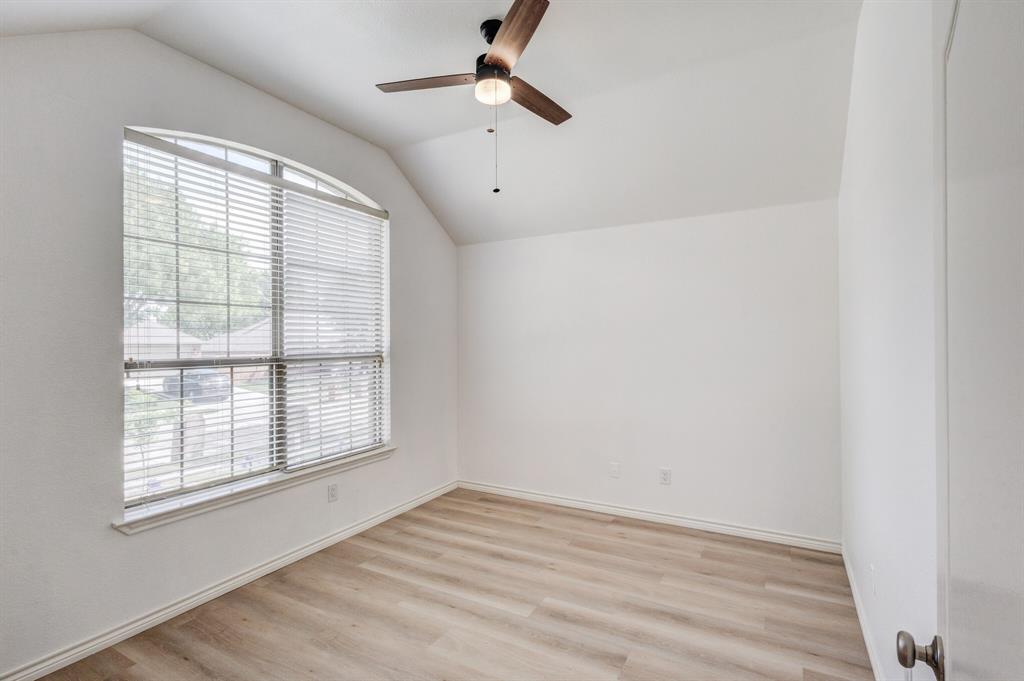 12405 Ark Road Frisco, TX 75035 - Photo 6 of 34 Unfurnished room featuring vaulted ceiling, light wood-style floors, and ceiling fan