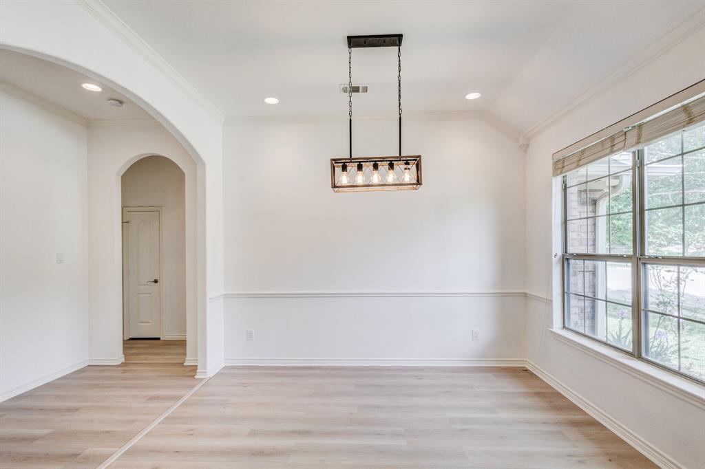 12405 Ark Road Frisco, TX 75035 - Photo 7 of 34 Unfurnished dining area featuring light wood finished floors, ornamental molding, recessed lighting, and arched walkways