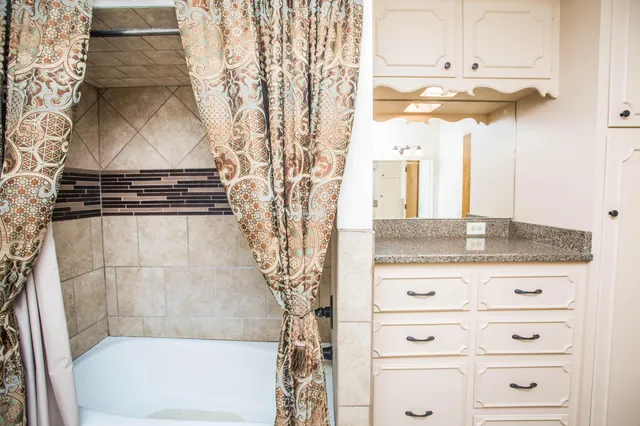 a bathroom with a granite countertop sink a vanity and a mirror